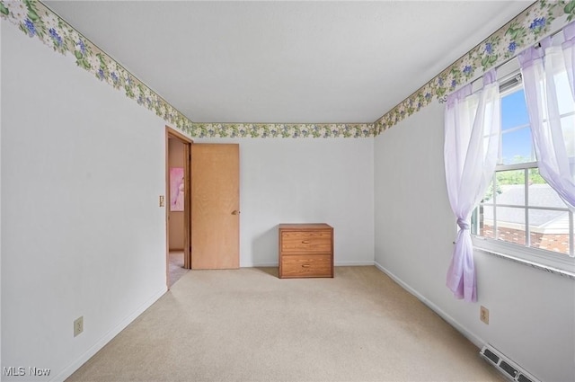 empty room featuring carpet floors and baseboards