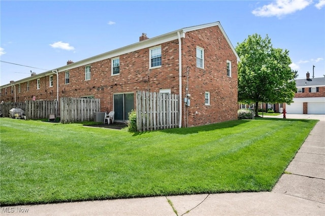 view of home's exterior with a chimney, central air condition unit, and brick siding