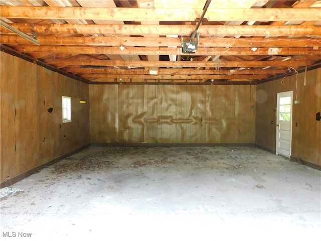 garage featuring a garage door opener and wood walls