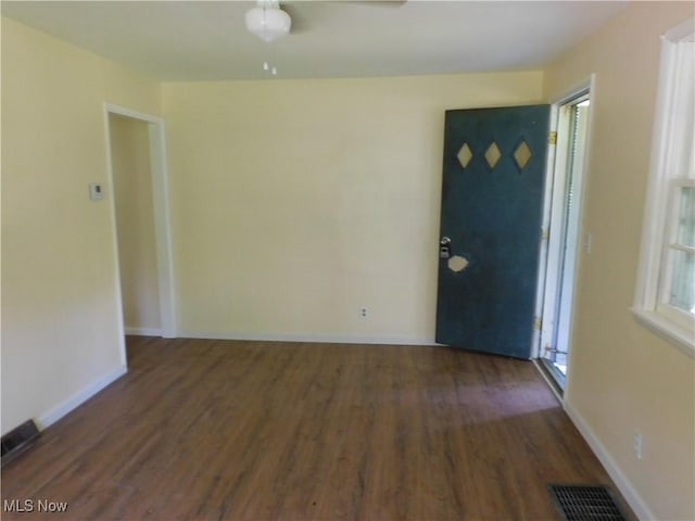 spare room featuring wood finished floors, baseboards, and ceiling fan