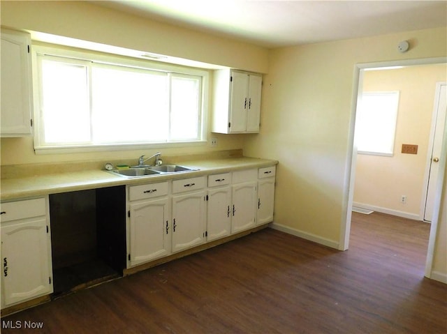 kitchen featuring a sink, dark wood-type flooring, white cabinetry, and baseboards