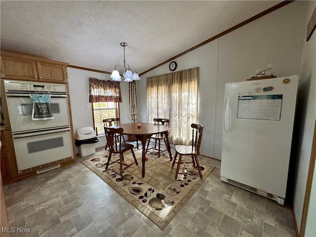 9400 Chalon Rd, Scio, OH 43988 - dining area with stone finish floors, a chandelier, vaulted ceiling, a textured ceiling, and ornamental molding