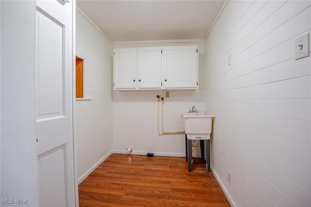 3153 SW Boltz Orchard Rd, Sugarcreek, OH 44681 - laundry area with wood finished floors, cabinet space, baseboards, wood walls, and ornamental molding