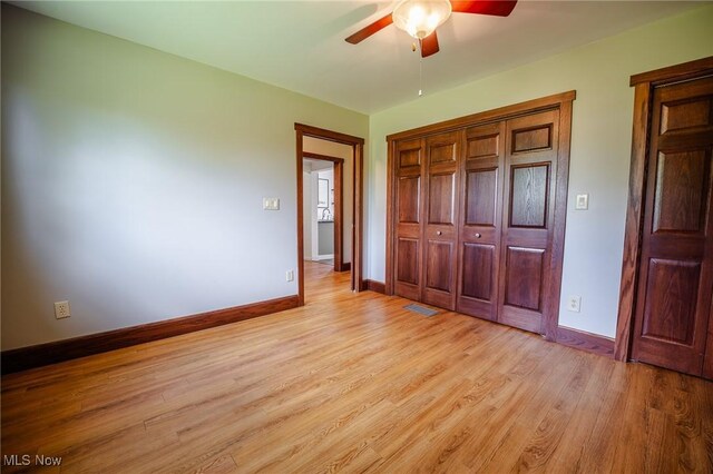 3153 SW Boltz Orchard Rd, Sugarcreek, OH 44681 - unfurnished bedroom featuring baseboards, light wood-style floors, a closet, and ceiling fan