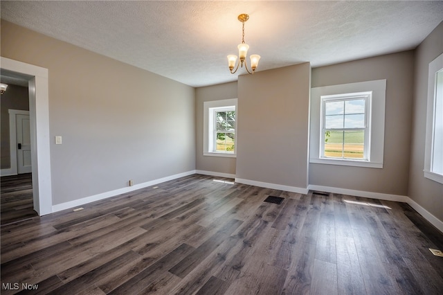 3153 SW Boltz Orchard Rd, Sugarcreek, OH 44681 - empty room with a chandelier, dark wood finished floors, baseboards, and a textured ceiling