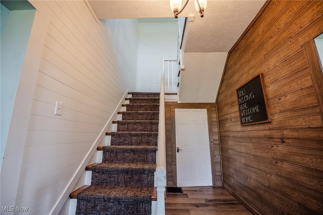3153 SW Boltz Orchard Rd, Sugarcreek, OH 44681 - staircase featuring wood walls, wood finished floors, and a textured ceiling