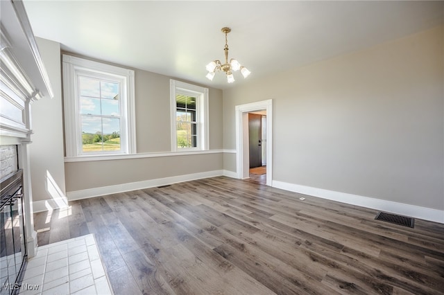 3153 SW Boltz Orchard Rd, Sugarcreek, OH 44681 - unfurnished dining area with a chandelier, a glass covered fireplace, wood finished floors, and baseboards