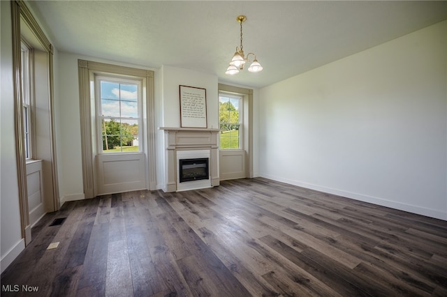 3153 SW Boltz Orchard Rd, Sugarcreek, OH 44681 - unfurnished living room with dark wood-style flooring, a chandelier, a glass covered fireplace, and baseboards