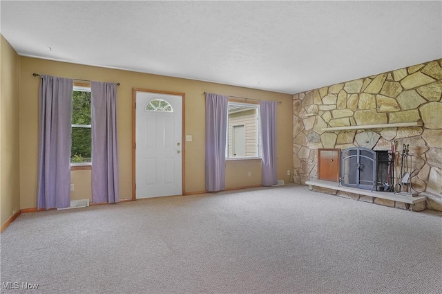 12395 Carter Rd, Concord, OH 44077 - unfurnished living room featuring carpet floors, a stone fireplace, and baseboards