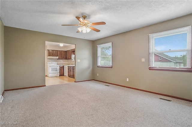 12395 Carter Rd, Concord, OH 44077 - unfurnished living room featuring light carpet, a ceiling fan, and baseboards
