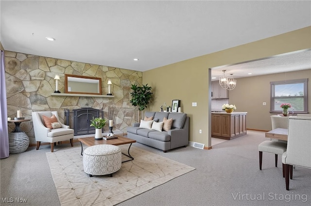 12395 Carter Rd, Concord, OH 44077 - living room with a chandelier, a stone fireplace, light colored carpet, baseboards, and recessed lighting