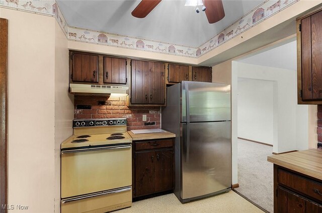 kitchen featuring freestanding refrigerator, white electric range, under cabinet range hood, a ceiling fan, and dark brown cabinets