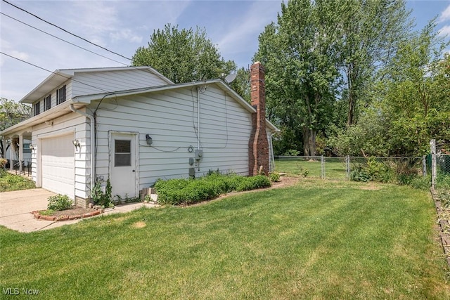 view of side of property with a chimney, concrete driveway, and a garage