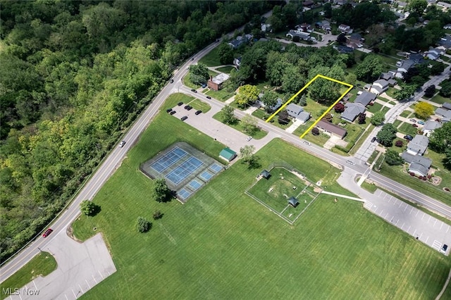 aerial view of property and surrounding area featuring property parcel outlined and a forest