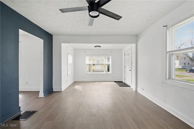 423 Kansas Ave, Lorain, OH 44052 - unfurnished living room featuring wood finished floors, baseboards, a textured ceiling, and a ceiling fan