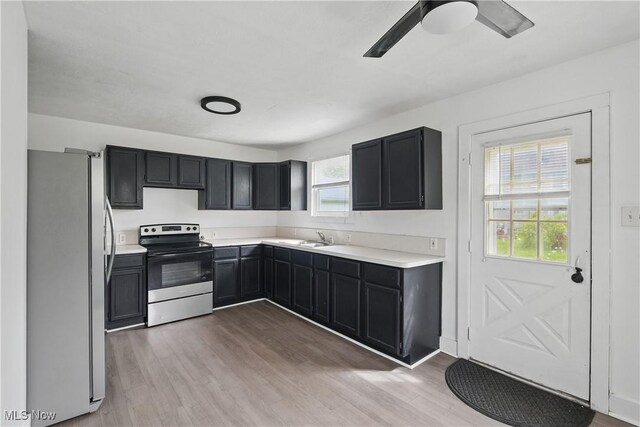 423 Kansas Ave, Lorain, OH 44052 - kitchen with stainless steel appliances, a sink, wood finished floors, and dark cabinets