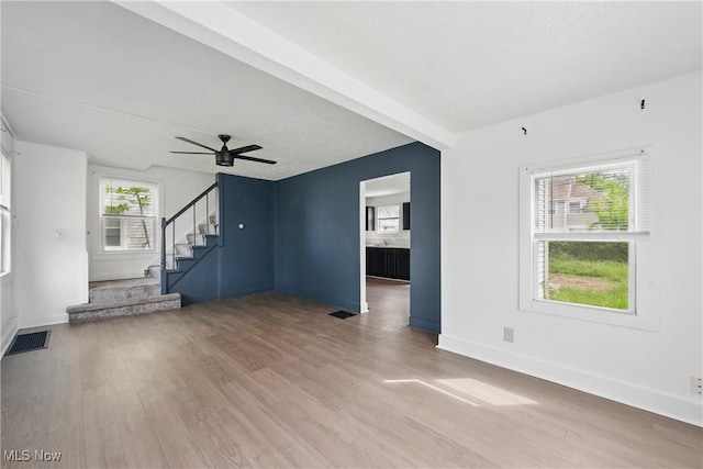 423 Kansas Ave, Lorain, OH 44052 - unfurnished living room featuring wood finished floors, stairs, ceiling fan, and baseboards