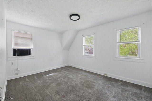 423 Kansas Ave, Lorain, OH 44052 - additional living space featuring dark colored carpet, a textured ceiling, cooling unit, and baseboards