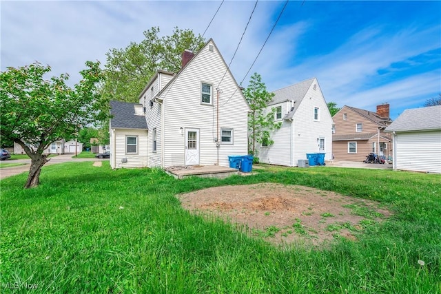 423 Kansas Ave, Lorain, OH 44052 - back of property with a chimney and a lawn