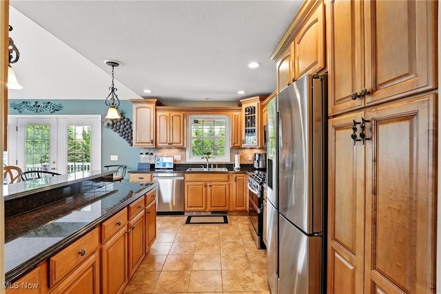 6868 Twin Oaks Ct, Canfield, OH 44406 - kitchen featuring stainless steel appliances, dark stone countertops, hanging light fixtures, decorative backsplash, and a sink