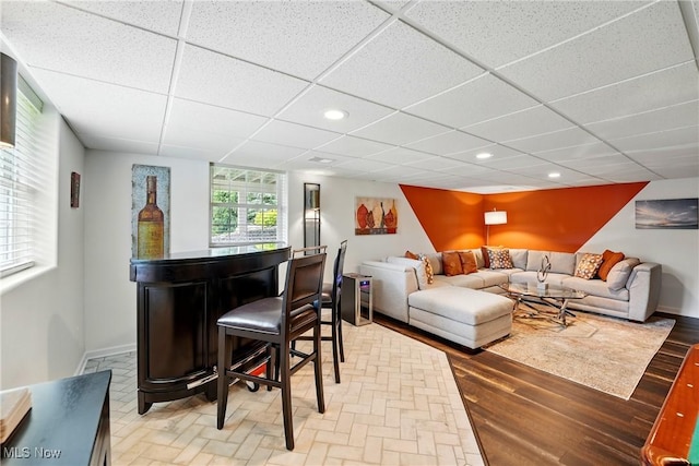 6868 Twin Oaks Ct, Canfield, OH 44406 - living area featuring a bar, a paneled ceiling, baseboards, recessed lighting, and light wood-type flooring