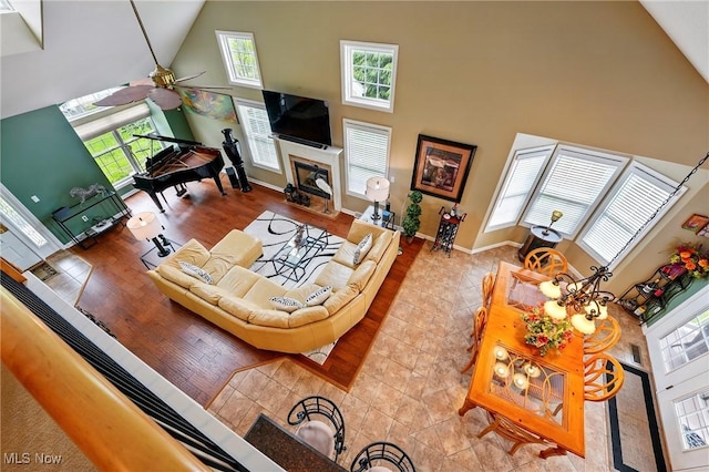 6868 Twin Oaks Ct, Canfield, OH 44406 - living room featuring high vaulted ceiling, healthy amount of natural light, ceiling fan, a fireplace with flush hearth, and baseboards