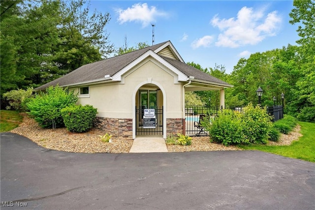 6868 Twin Oaks Ct, Canfield, OH 44406 - view of front facade with stucco siding, stone siding, and a shingled roof