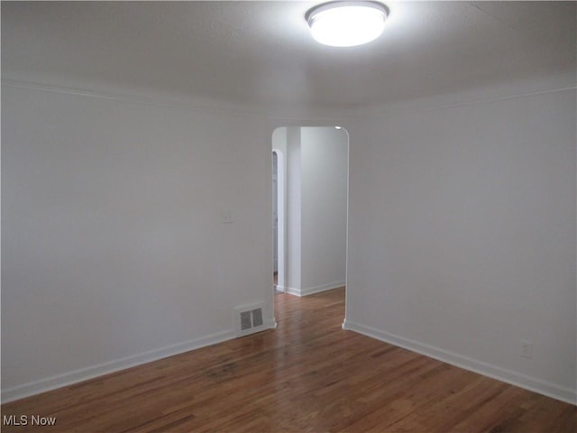 1397 Sunset Rd, Mayfield Heights, OH 44124 - unfurnished room featuring arched walkways, wood finished floors, ornamental molding, and baseboards