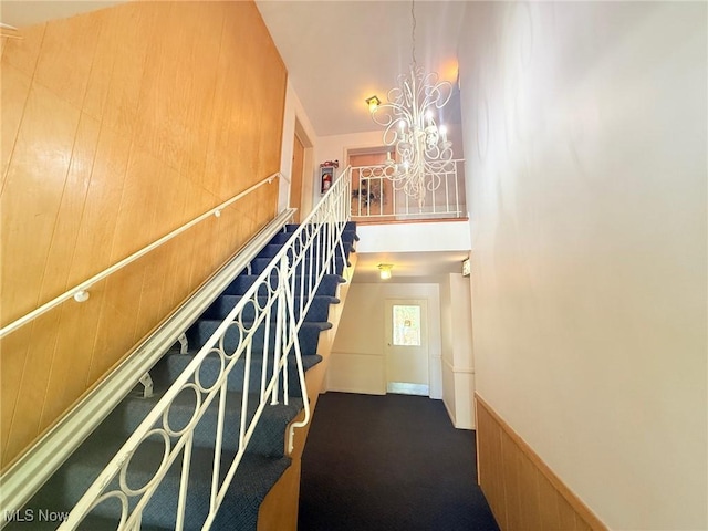 staircase with a chandelier