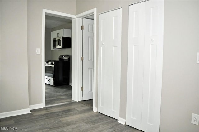 hallway with dark wood-style floors and baseboards