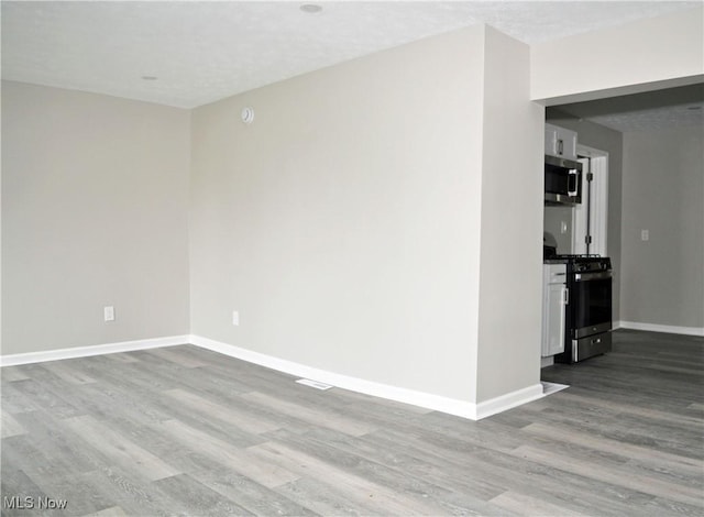 unfurnished room featuring wood finished floors and baseboards