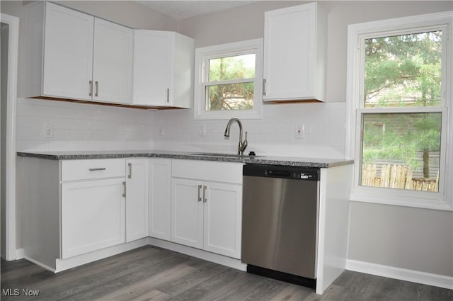 kitchen with stainless steel dishwasher, a sink, white cabinetry, tasteful backsplash, and dark wood finished floors