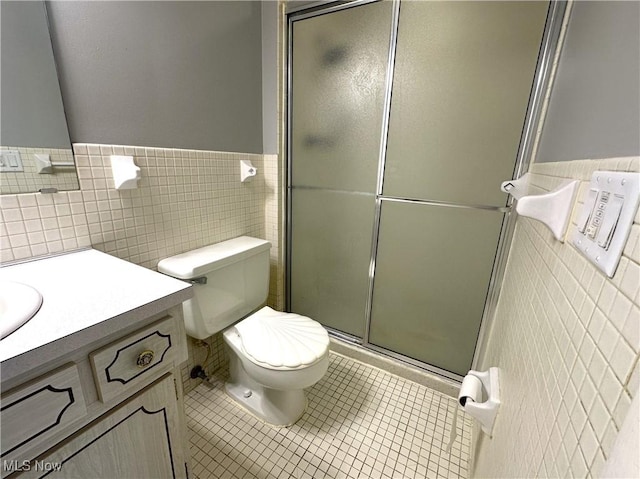 2600 Greenlawn Dr, Seven Hills, OH 44131 - bathroom featuring tile walls, tile patterned flooring, a shower stall, vanity, and a wainscoted wall