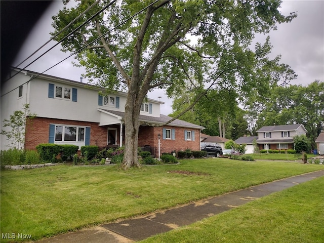 5124 Northcliff Loop W, Columbus, OH 43229 - traditional-style home with brick siding, a front lawn, and stucco siding