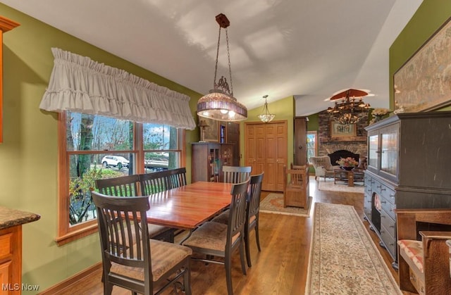38 Choctaw Trl, Malvern, OH 44644 - dining area with a stone fireplace, plenty of natural light, wood finished floors, and vaulted ceiling