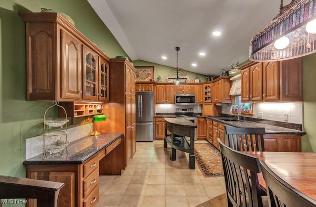 38 Choctaw Trl, Malvern, OH 44644 - kitchen featuring stainless steel appliances, vaulted ceiling, glass insert cabinets, dark stone countertops, and brown cabinets