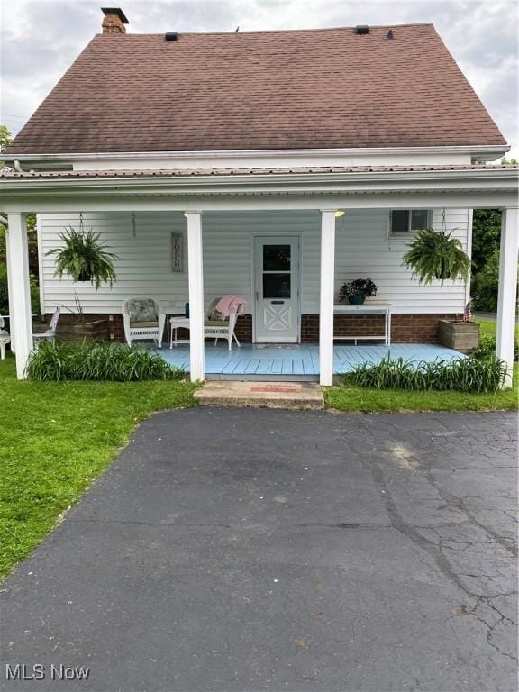 1912 Lisbon St, East Liverpool, OH 43920 - rear view of house featuring roof with shingles, a porch, a chimney, and a yard