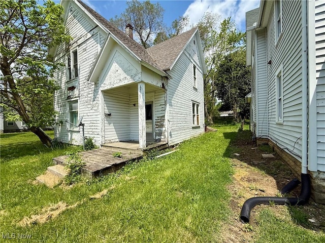926 W Wayne St, Lima, OH 45805 - view of side of property featuring a yard and a shingled roof