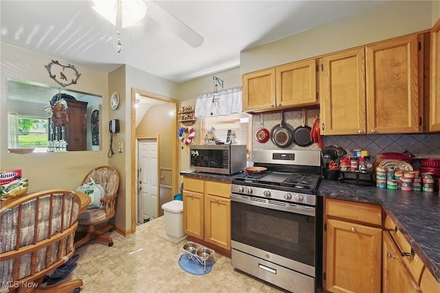 kitchen featuring stainless steel appliances, ceiling fan, and backsplash