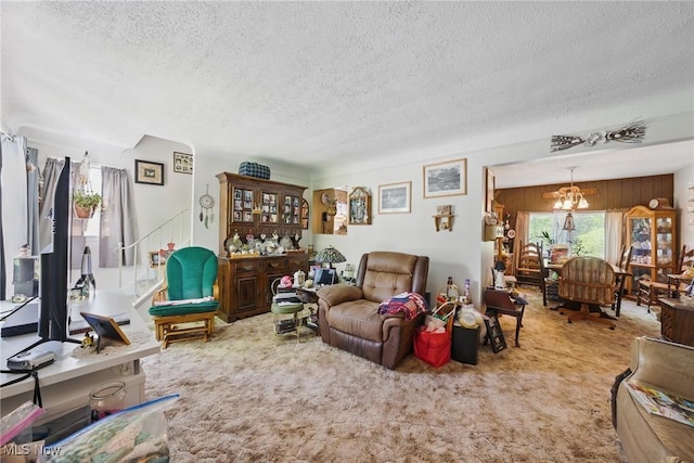living room featuring a textured ceiling, carpet floors, and a chandelier