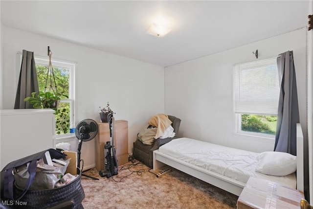 carpeted bedroom featuring multiple windows