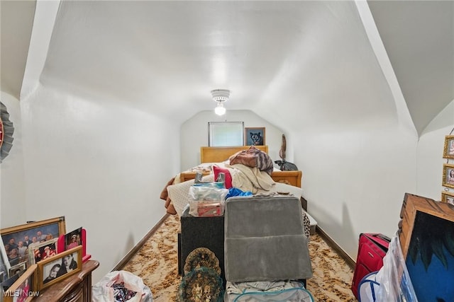 bedroom with lofted ceiling, carpet, and baseboards
