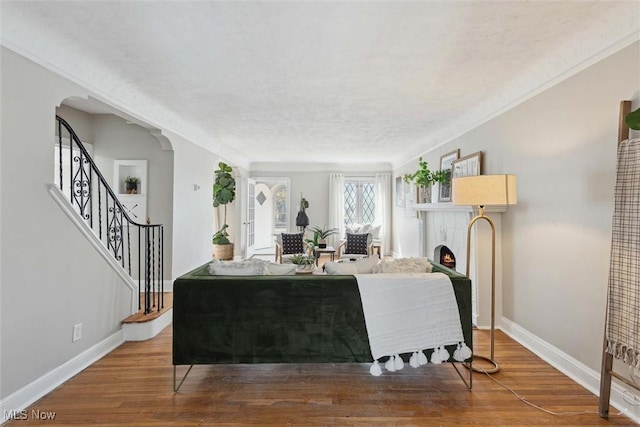 3569 Silsby Rd, University Heights, OH 44118 - living area featuring arched walkways, wood finished floors, a warm lit fireplace, and baseboards