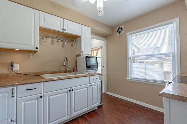 2930 Archwood Pl, Cuyahoga Falls, OH 44221 - kitchen with a sink, white cabinets, dark wood finished floors, baseboards, and ceiling fan
