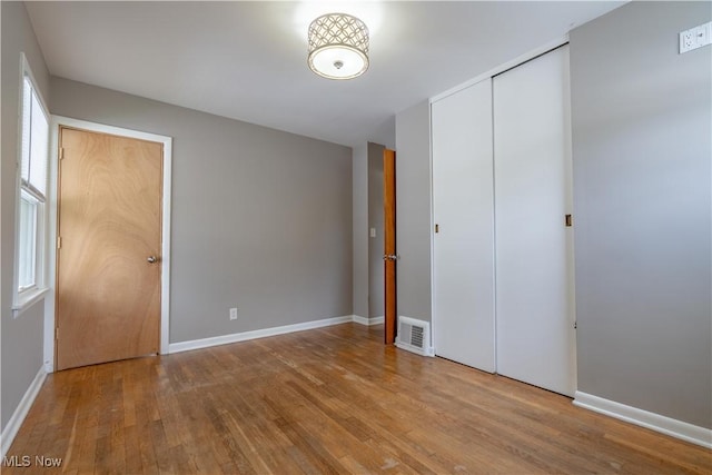 2930 Archwood Pl, Cuyahoga Falls, OH 44221 - unfurnished bedroom with wood finished floors, baseboards, and a closet