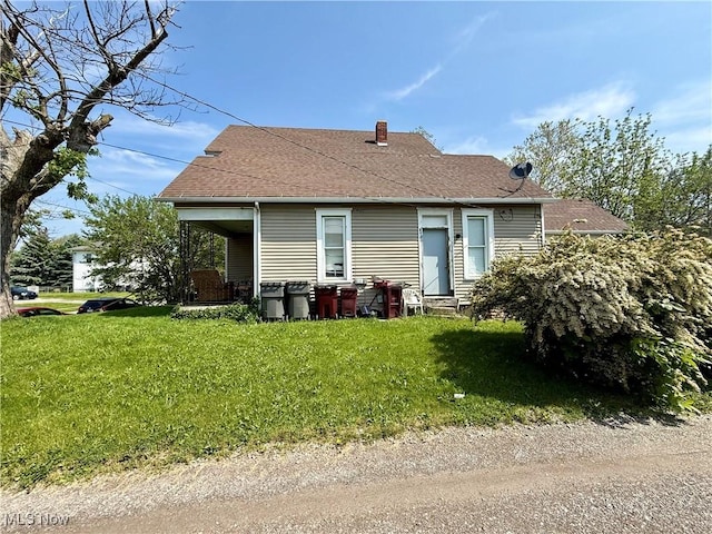 466 N Mcdonel St, Lima, OH 45801 - back of property with a lawn, a shingled roof, and a chimney