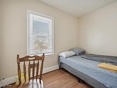 bedroom featuring wood finished floors and baseboards