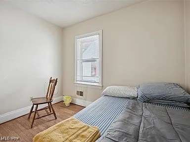 bedroom featuring baseboards and wood finished floors