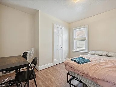 bedroom with baseboards and wood finished floors