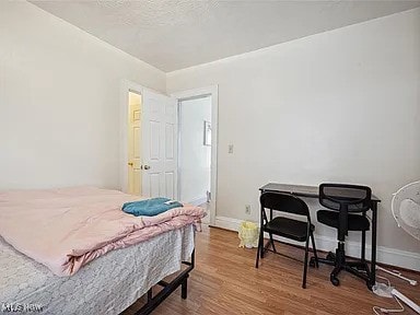 bedroom with wood finished floors and baseboards
